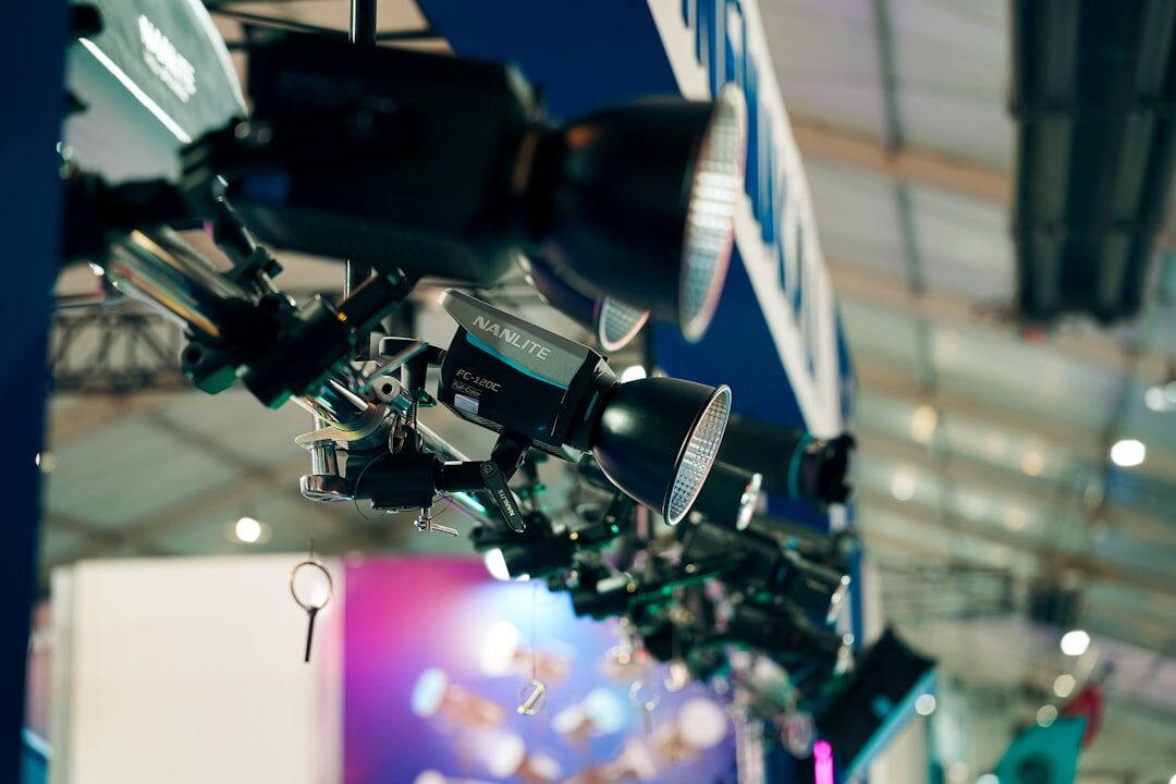 Row of broadcast cameras pointed at a stage during live event